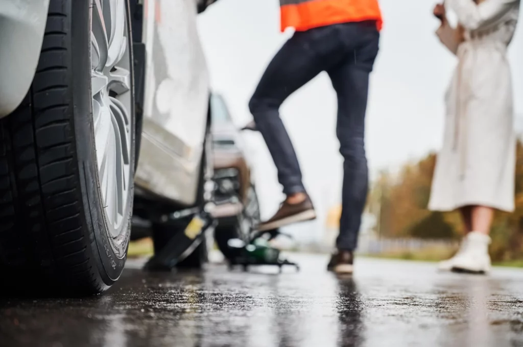 emergency auto mechanic repairing woman vehicle on the street